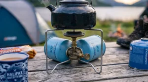 Studio shot of a classic blue Campingaz 206 puncture cartridge camping stove on a white background.