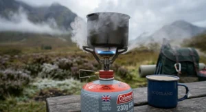 A screw top gas stove boiling water during a cold weather camping trip in the UK mountains.