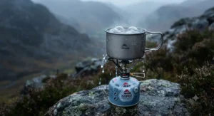 Close-up of the MSR PocketRocket stove boiling water in a titanium pot during a rainy UK hike.