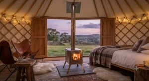 A stylish folding wood burning stove heating a luxury glamping yurt in the British countryside.